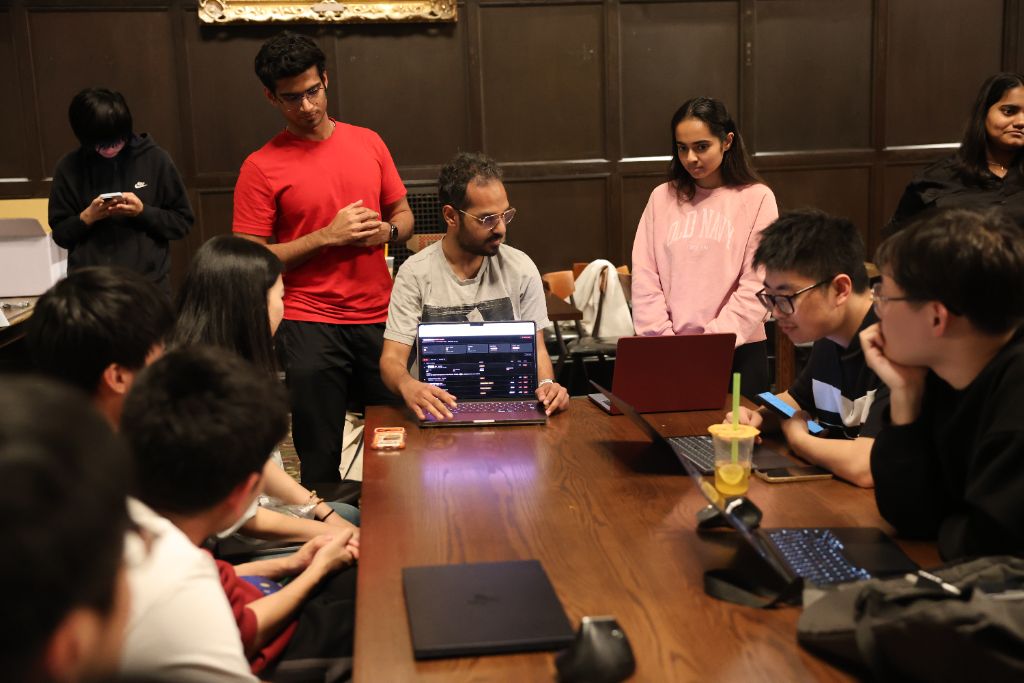 Students collaborating around laptops during an AI campus workshop session