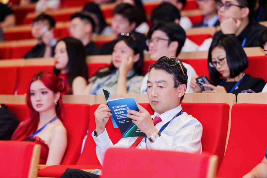 An attendee closely reading the GaGro Zhejiang Innovation Tour program booklet